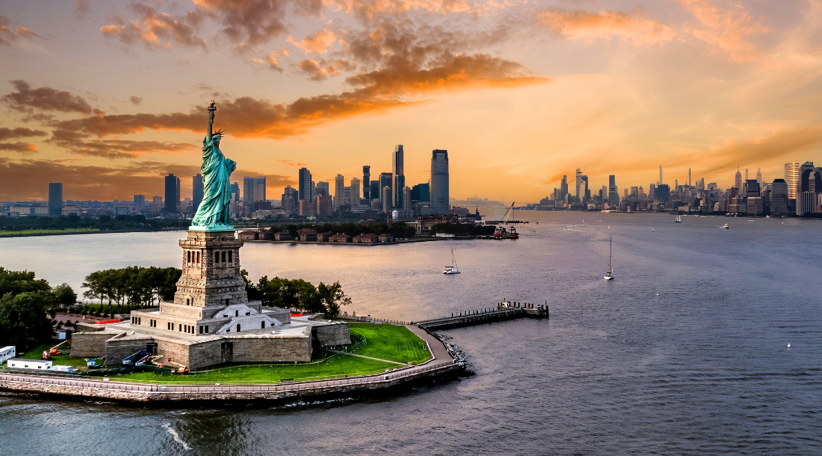 Regal image of the Statue of Liberty - A symbol of freedom and hope against the New York City skyline. The graceful copper figure stands tall, holding her torch aloft, while the sun's rays embrace her in a warm glow. The tranquil waters of the harbor provide a serene backdrop to this embodiment of liberty's enduring spirit.